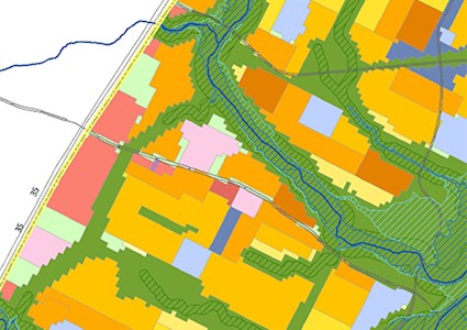 Map showing non developed areas in green with different structures in color including yellow, orange, blue and pink