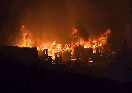 A night-time wildfire is burning up homes. 