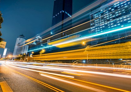 The image shows bright lights zooming along a highway. 