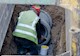 man works to install a concrete pipe underground